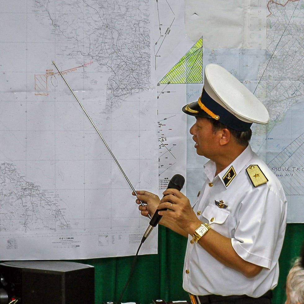Vietnamese Navy's Deputy Commander Rear Admiral Le Minh Thanh discusses the disappearance of MH 370 in March 2014 a map in a naval uniform points to a map with a pointer and speaks into a microphone