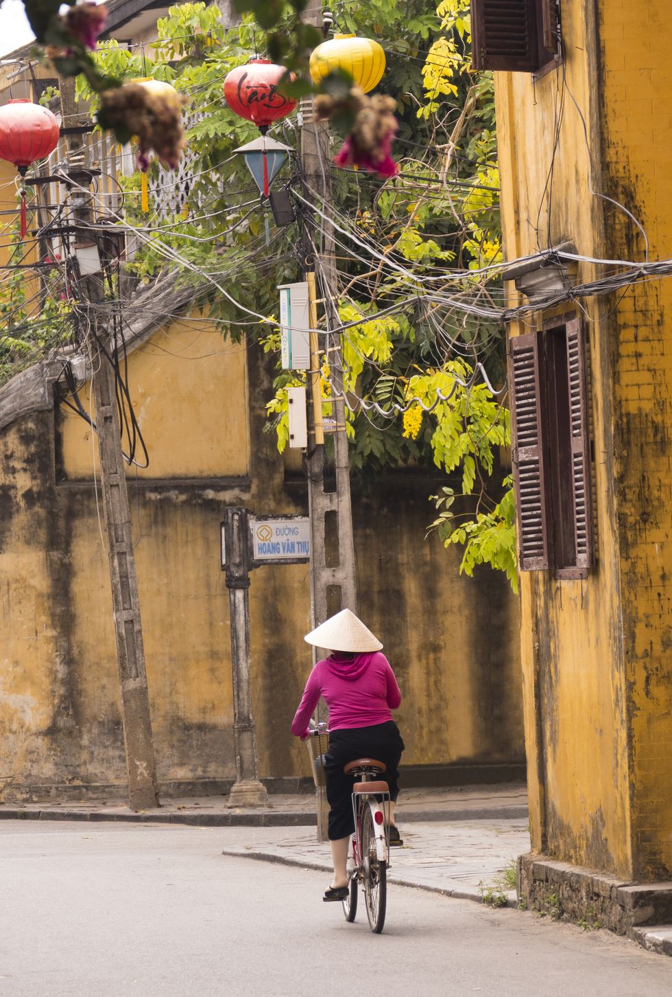 vietnamese woman on bike on street in ancient town hoi an in vietnam