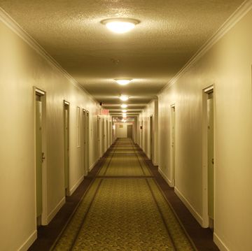 view down hotel corridor with illuminated lamps on ceiling