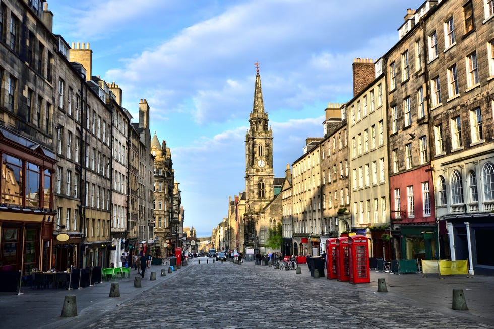 a cobblestone street with shops and historic buildings