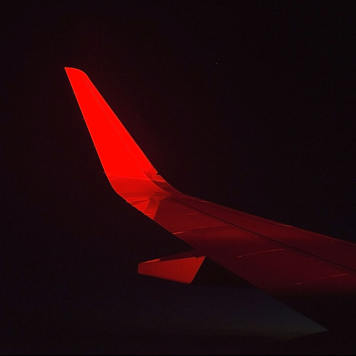 View of a airplane wing at night during a red eye flight