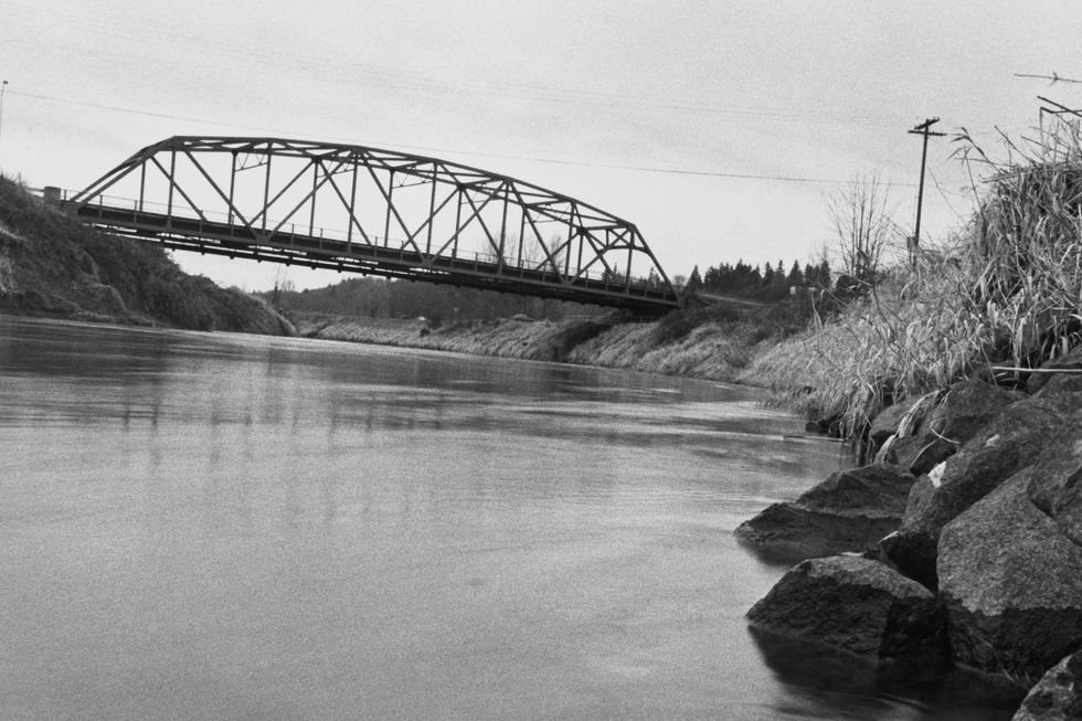 view of a river and a bridge across it in the distance
