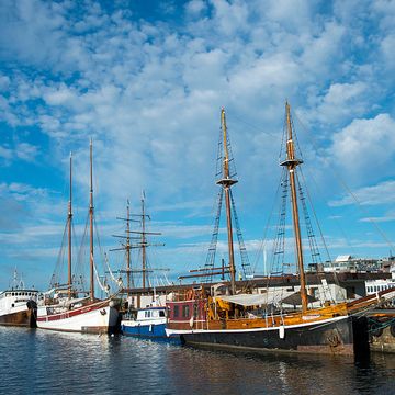 view of old sail boats docked in the harbor in front of the