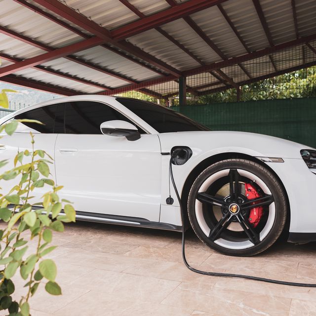 view of parked electric porsche car connected to the charging station in the garden garage