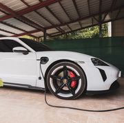 view of parked electric porsche car connected to the charging station in the garden garage