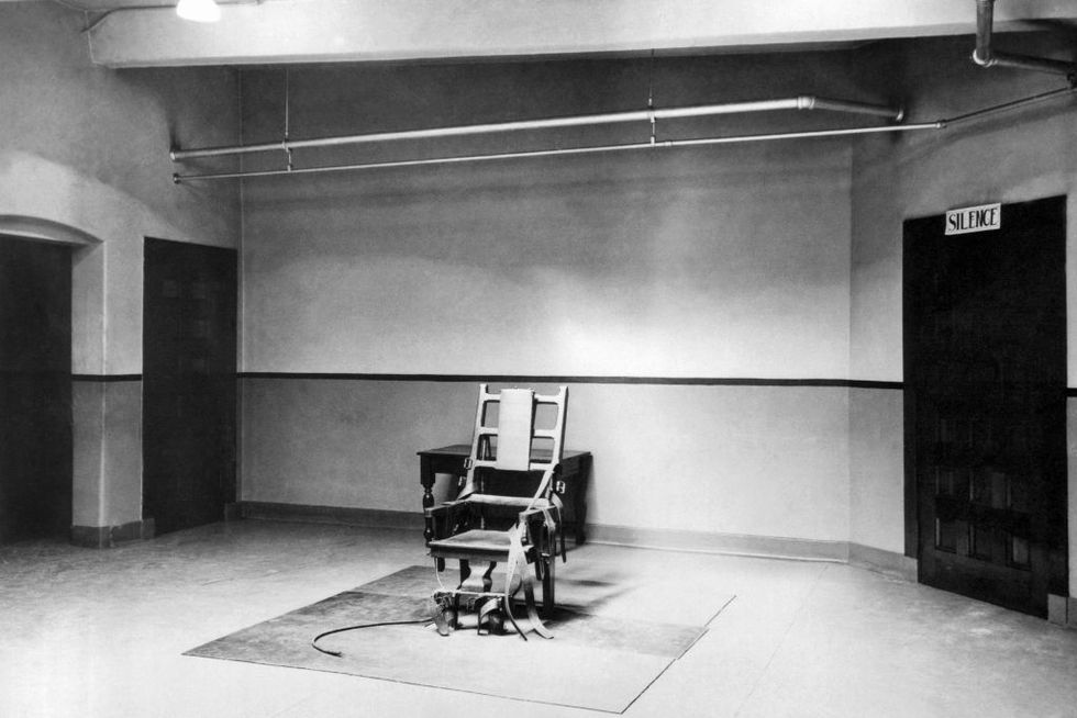 an electric chair sits in the middle of a mostly empty room