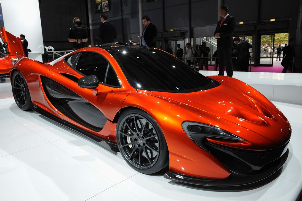 an orange sport car sits in a brightly lit showroom