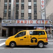 New York City Arts Venues Reopen At 33% Capacity new york city taxi cab near radio city music hall