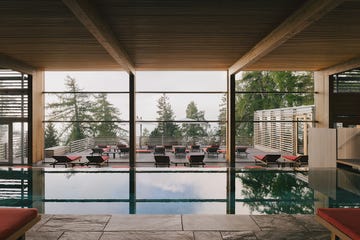 a swimming pool with a deck and chairs and a large window