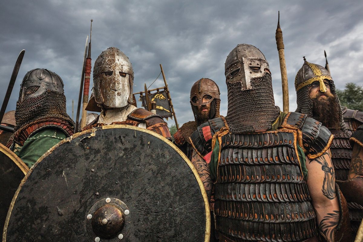Reenactors met een vastberaden blik in hun Vikinggevechtstenue van ijzer en leer