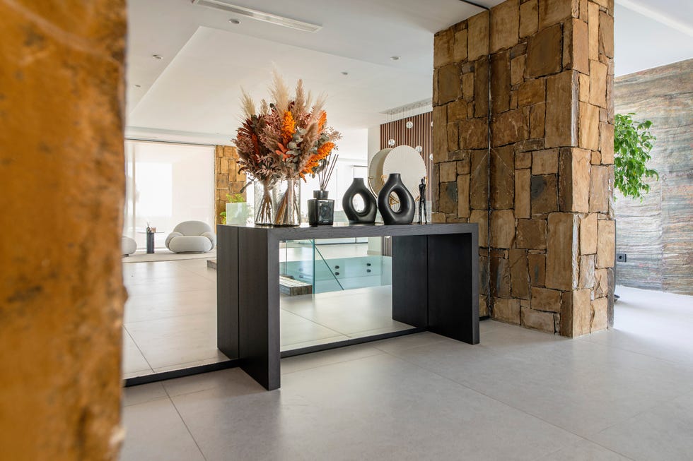 recibidor con consola de madera negra y pared de espejo