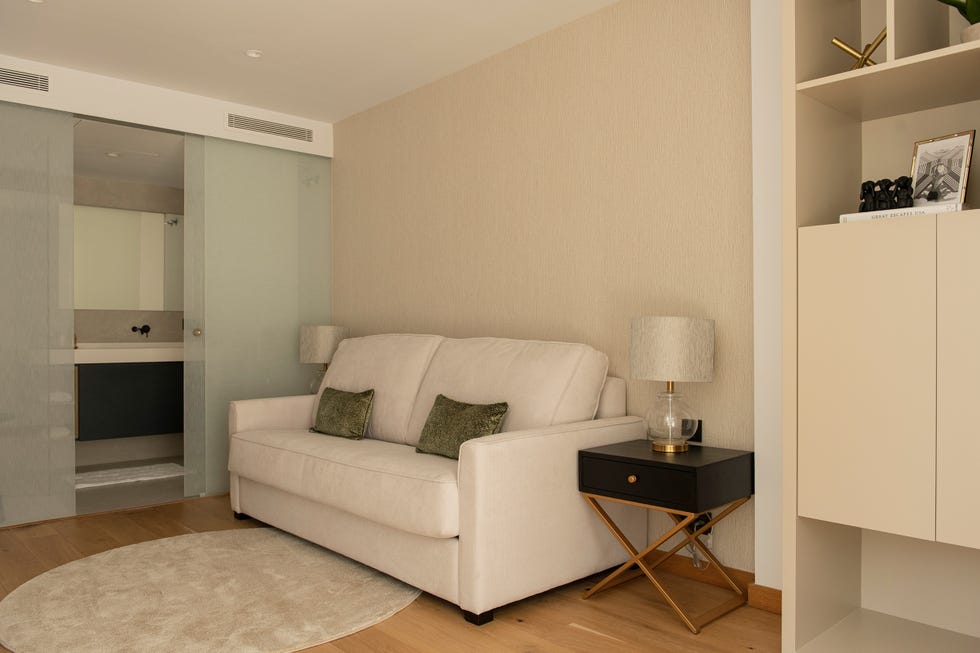 sofá blanco y puertas correderas de cristal con baño