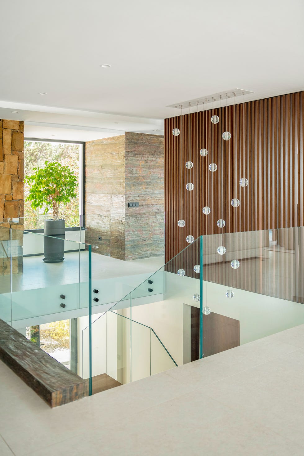escalera con pasamanos de vidrio y lámpara de techo con esferas de cristal