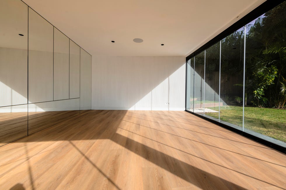 gimnasio con pared de espejos, suelo de pared y ventanas de suelo a techo