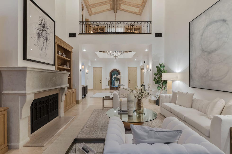 salón abierto de estilo clásico decorado en blanco con doble altura