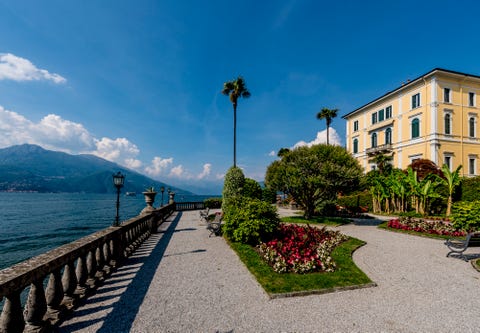 lakeside building with gravel path and gardens