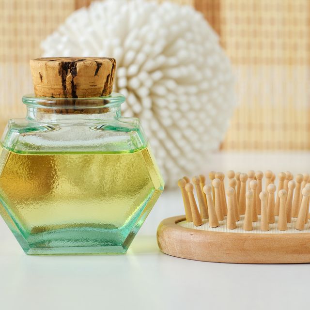vintage bottle with cosmetic oil and wooden hair brush. homemade spa and beauty treatment recipe. copy space.