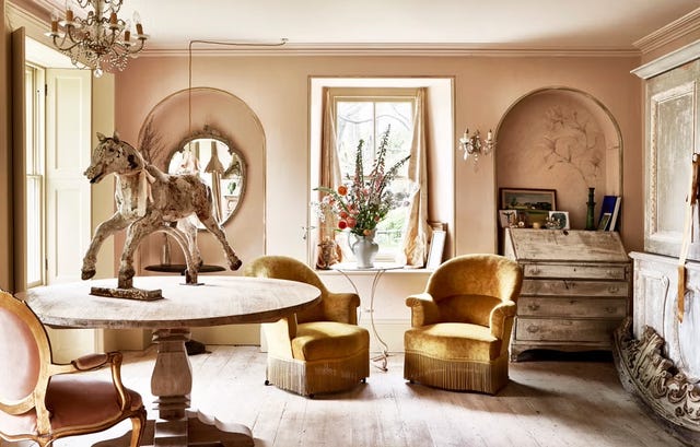 a warmly decorated living space featuring a large round wooden table at the centre