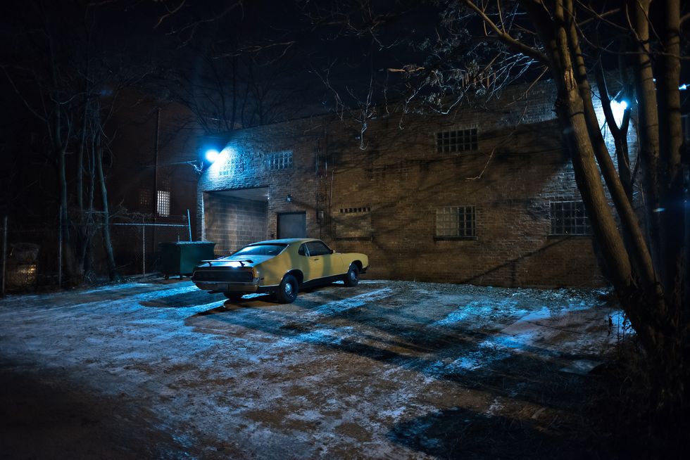 vintage muscle car in a dark chicago city urban alley on a winter night