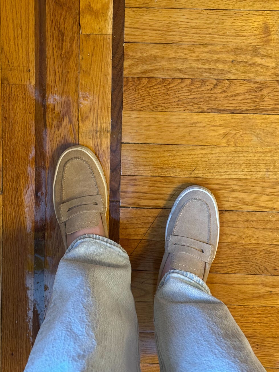 a person wearing beige vionic uptown loafers on hardwood floors