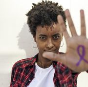 black woman with international women's day ribbon on hand