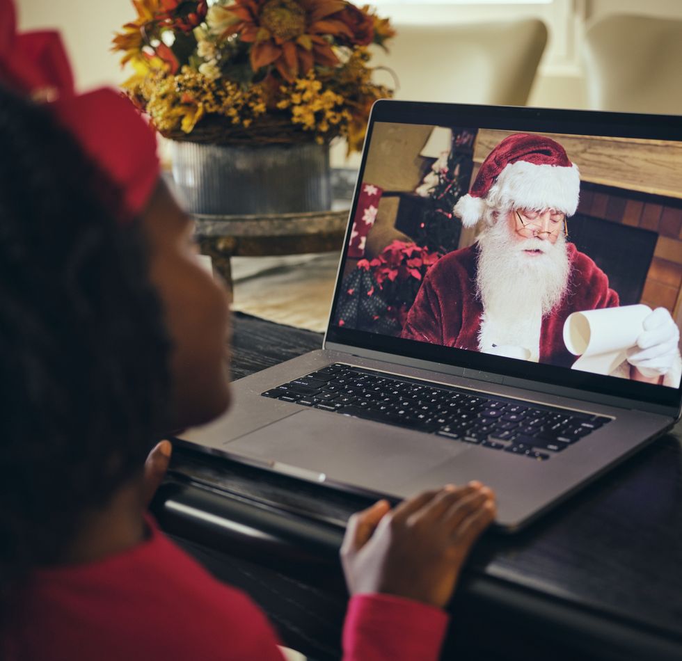 a little girl, talking to santa claus on a computer video conference call