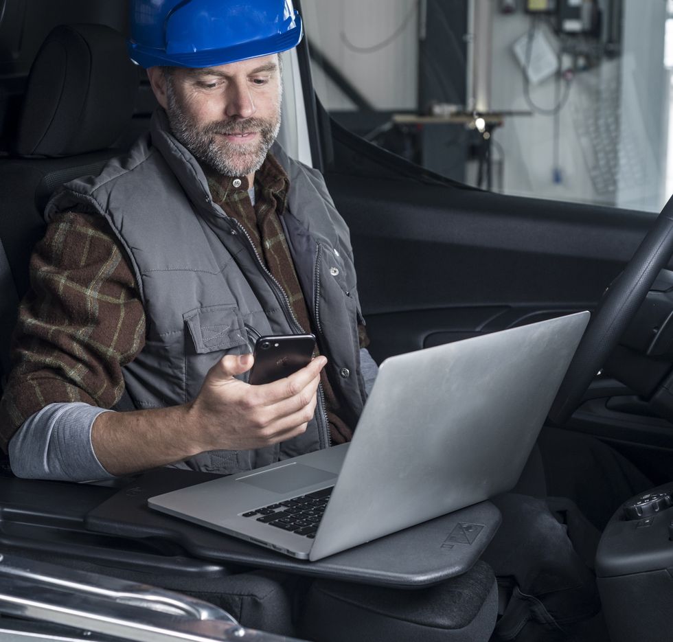 a person in a hard hat using a laptop