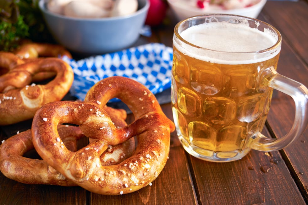 traditional munich pretzel next to mug of beer on wooden tabele for beer fest close up