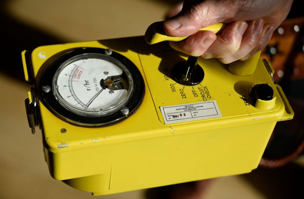 hand with a yellow geiger counter
