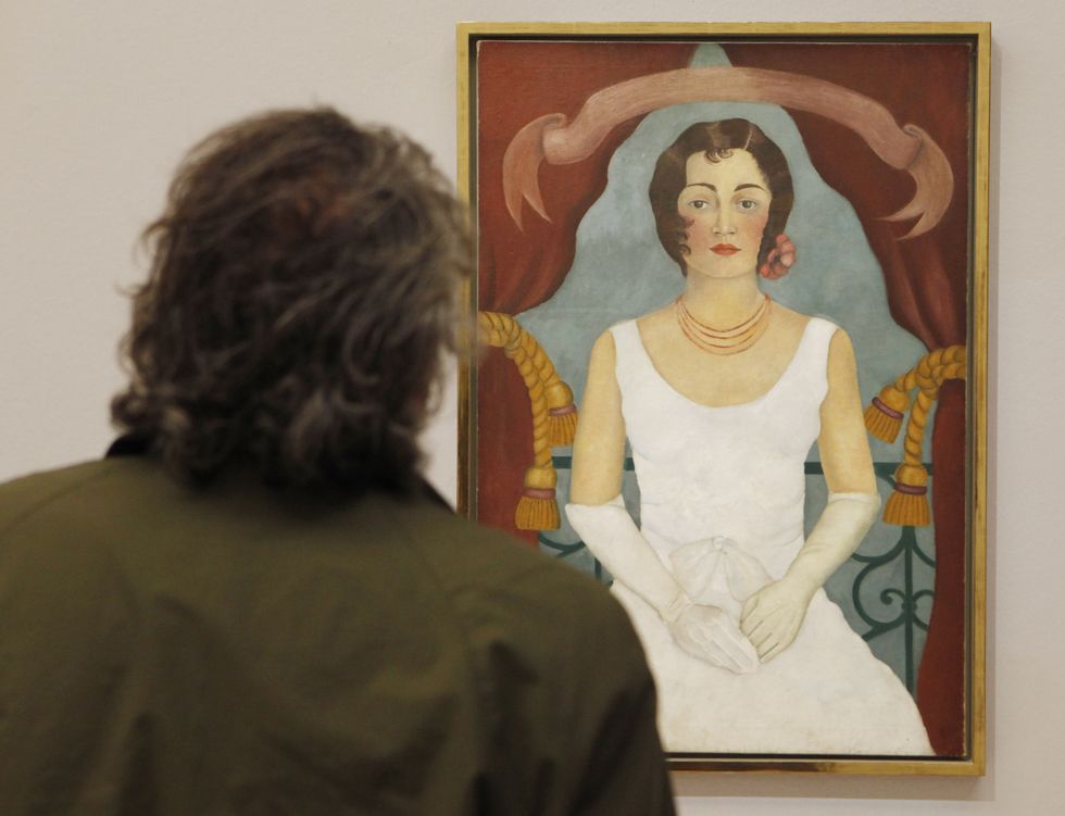 a visitor looks at a painting by mexican
