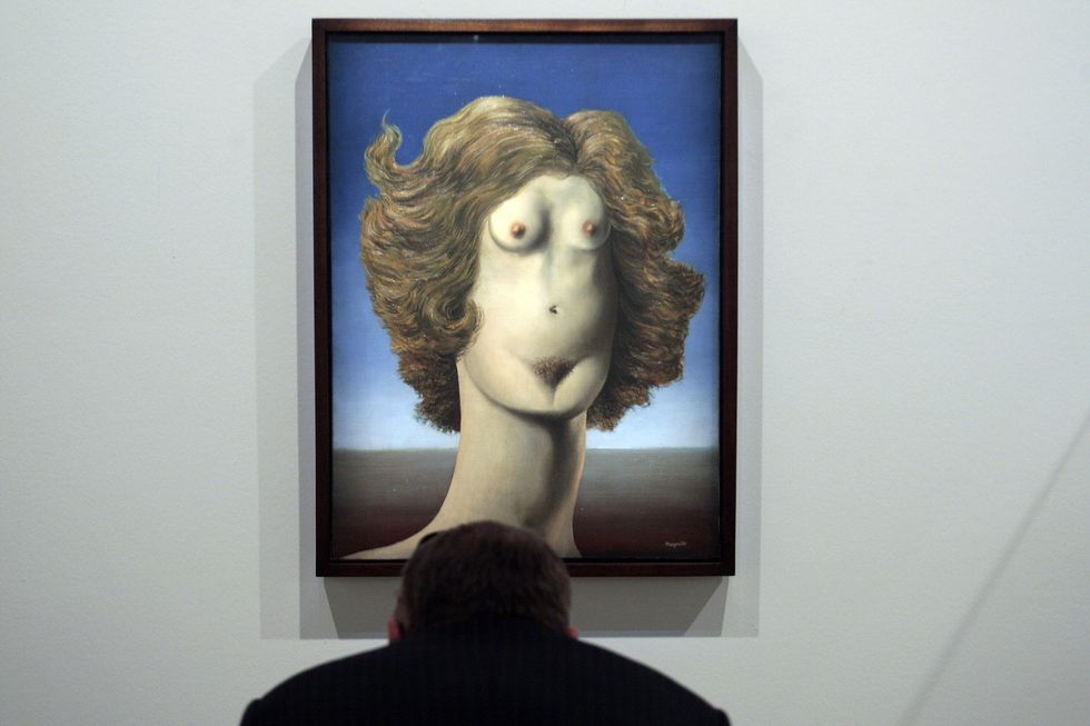 a visitor looks at a rene magritte 1898