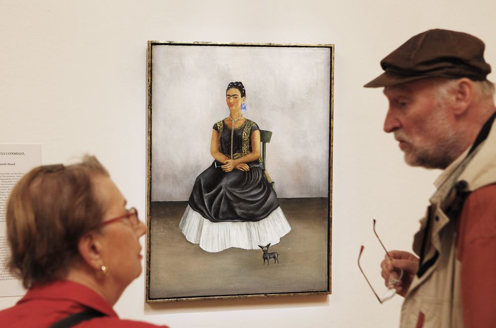 visitors look at a painting by mexican a