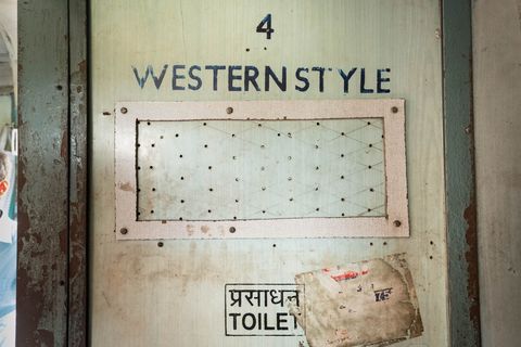 De ingang van een toilet op de Vivek Express wordt omlijst door afbladderende verf  een van de minder aangename aspecten van de lange treinreis