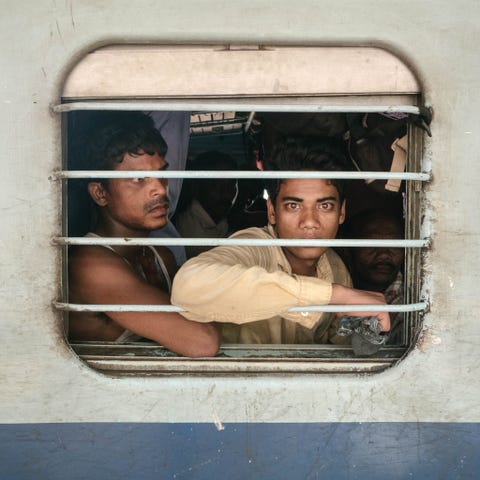 Passagiers staren uit het raampje van een tweedeklascoup Velen van hen zijn gastarbeiders die naar hun deelstaat Assam terugkeren nadat ze in het zuiden in beter betaalde banen hebben gewerkt Anderen zijn lokale reizigers die een paar stations verderop weer uitstappen Mensen stappen in en uit zegt Paley Aan hun gezichtsuitdrukkingen kleding en zelfs het voedsel kun je zien door welke plaatsen we komen
