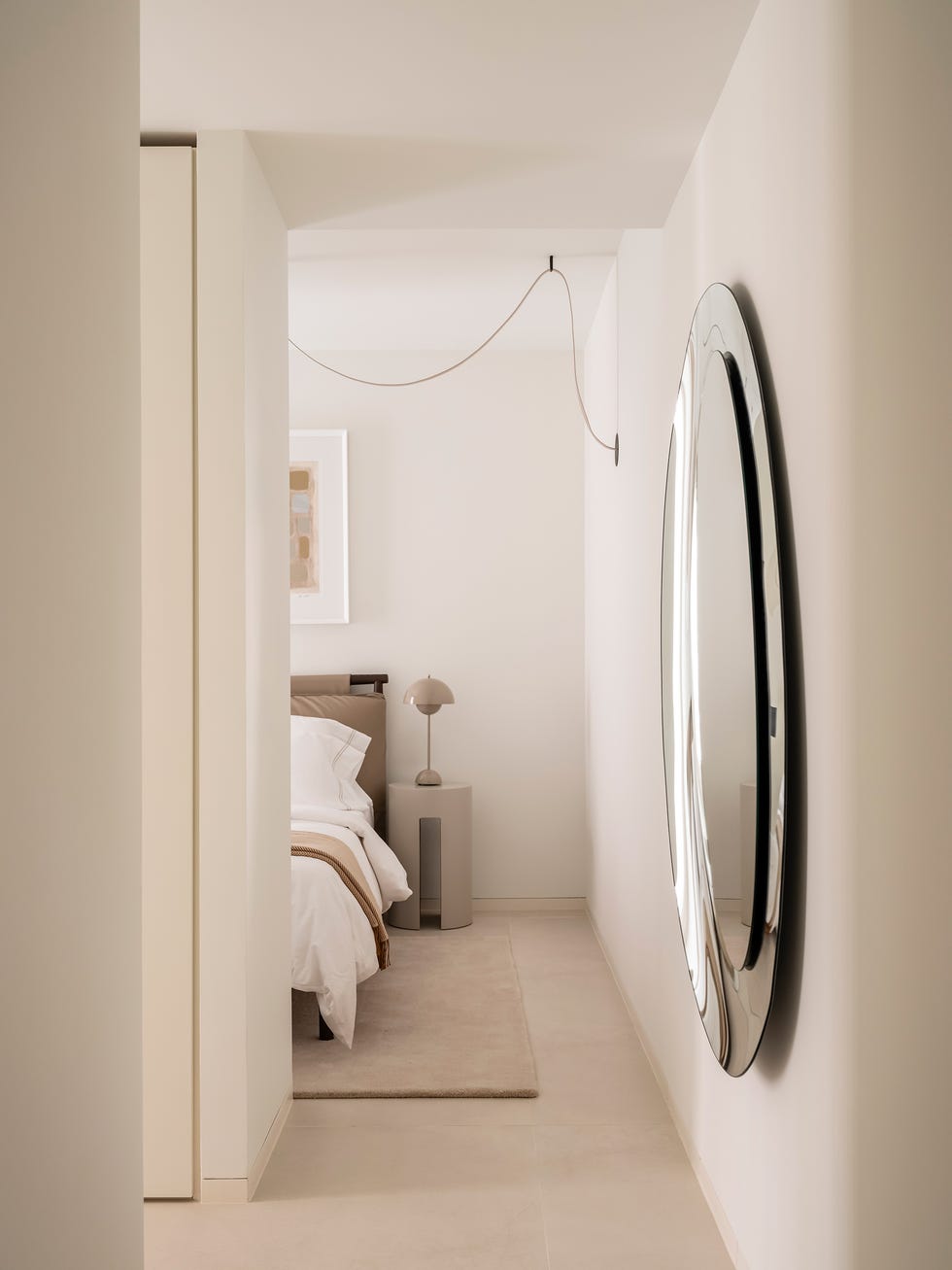 dormitorio con espejo redondo en la pared