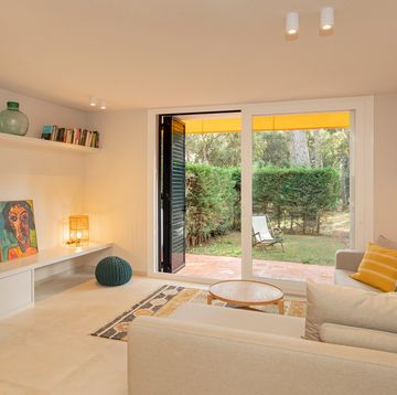 salón con sofá beige rinconera y acceso a la terraza