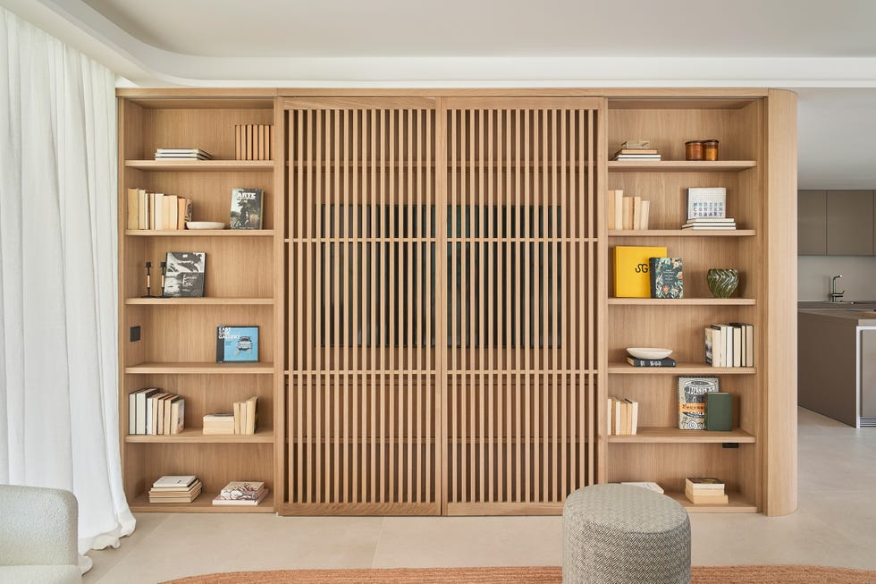 salón con estantería de madera con frente de palillería