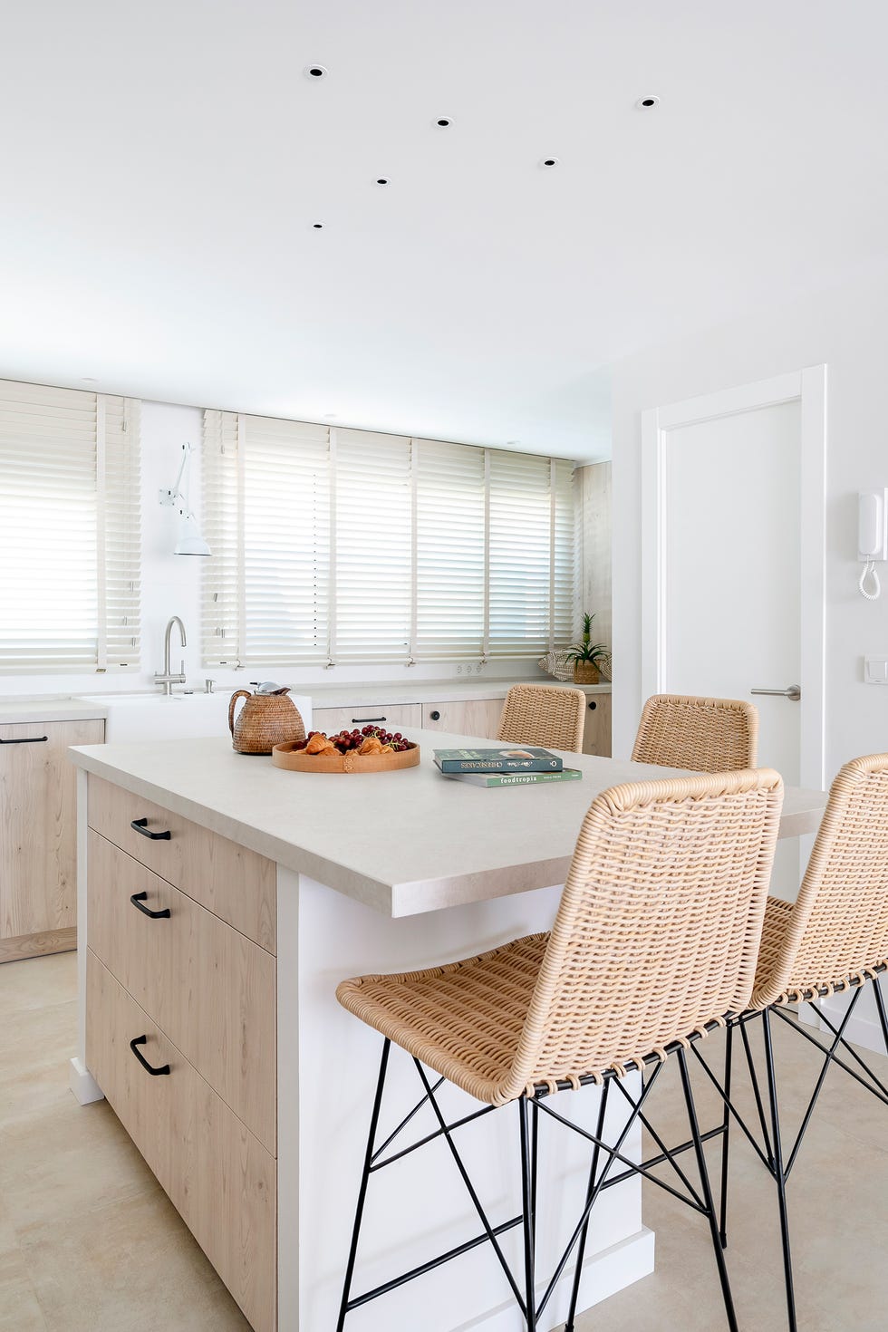 cocina con frentes de madera e isla central con taburetes