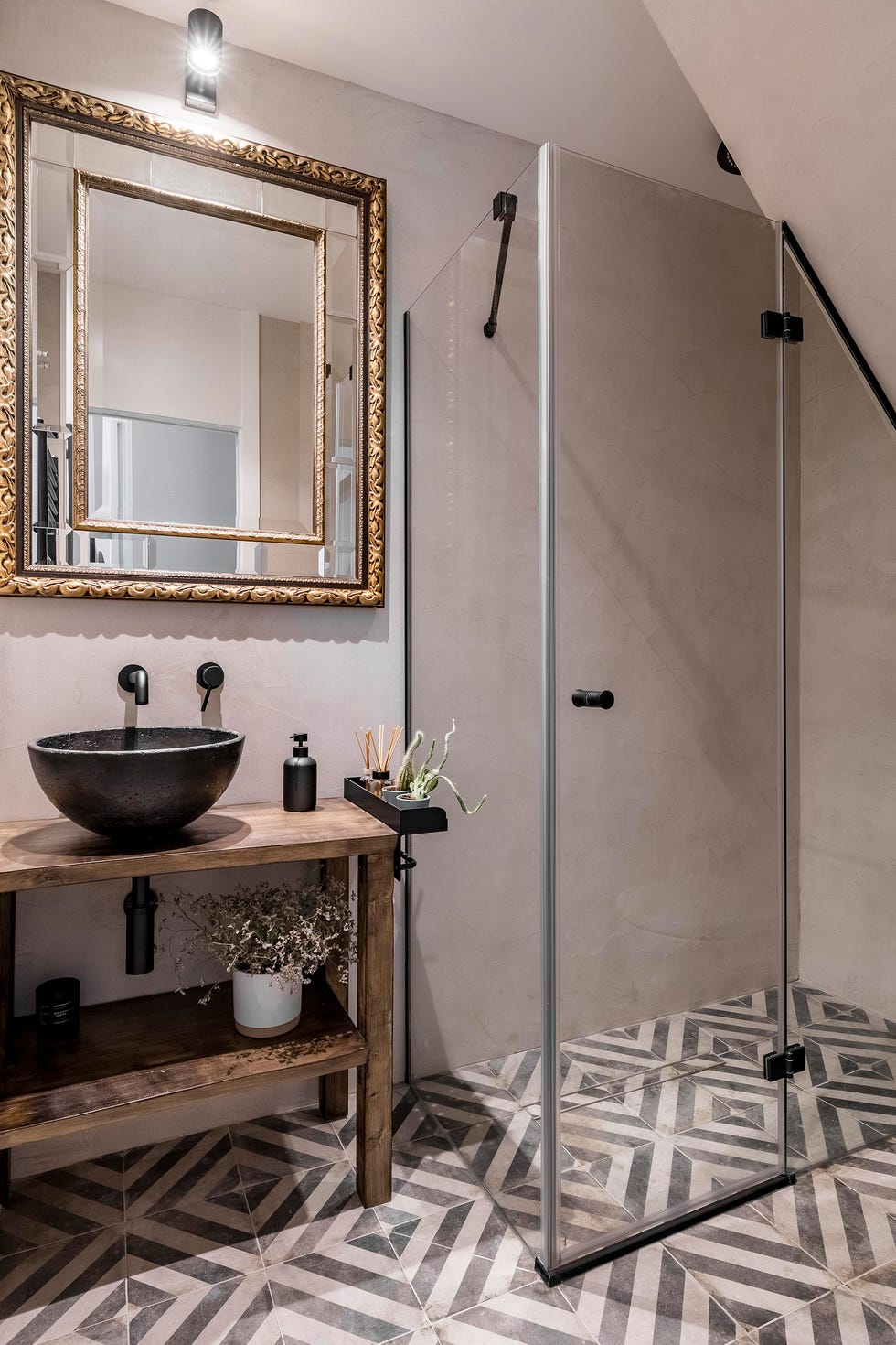 mueble de madera, lavabo exento, espejo con marco dorado y suelo de baldosas geométricas