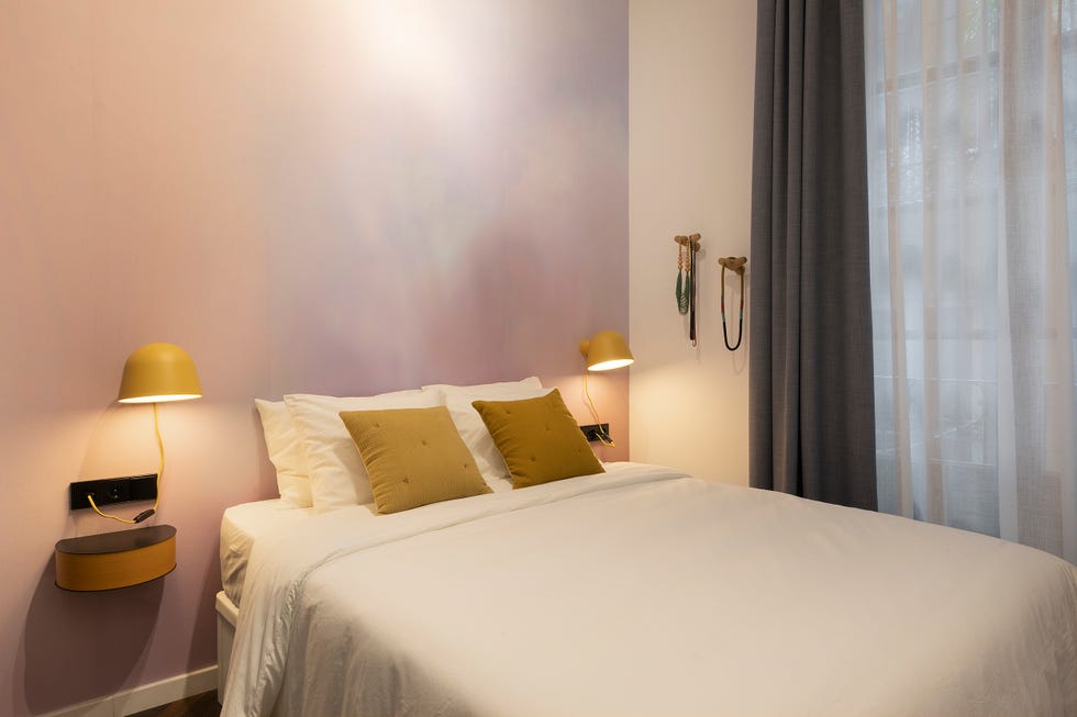 dormitorio moderno con papel pintado rosa y apliques amarillos