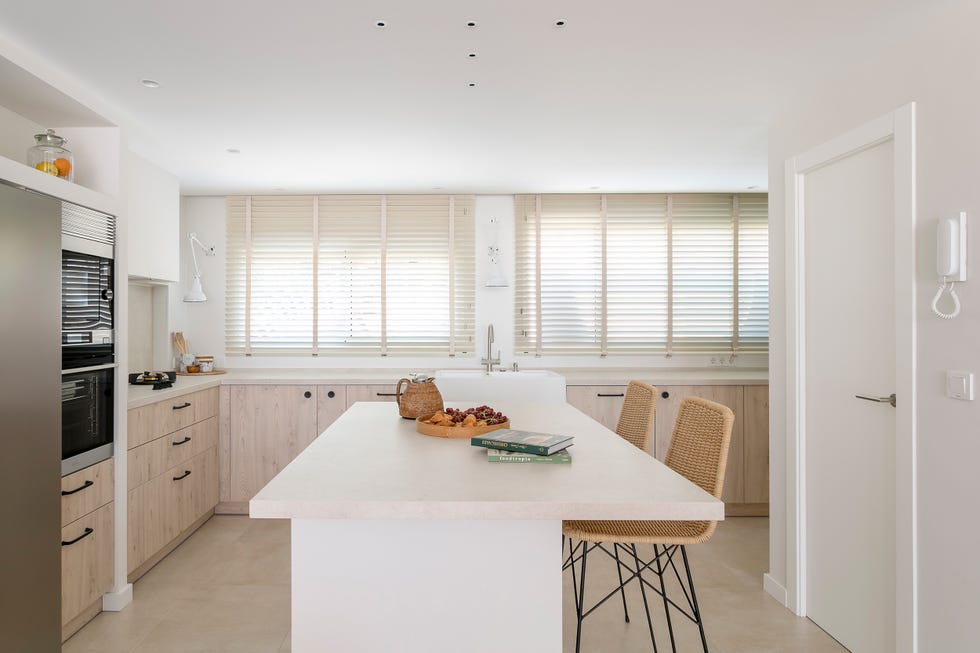 cocina con frentes de madera e isla central con taburetes