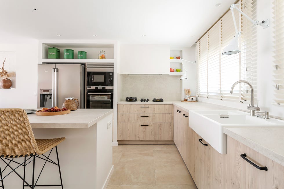 cocina con frentes de madera e isla central con taburetes