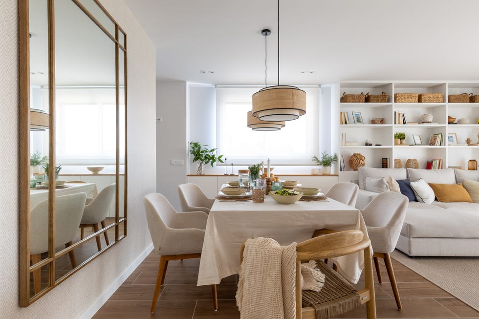 comedor con sillas tapizadas en beige, sillas de madera y lámparas suspendidas con pantallas redondas