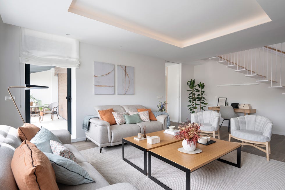 salón con sofás, butacas y mesas de centro de madera