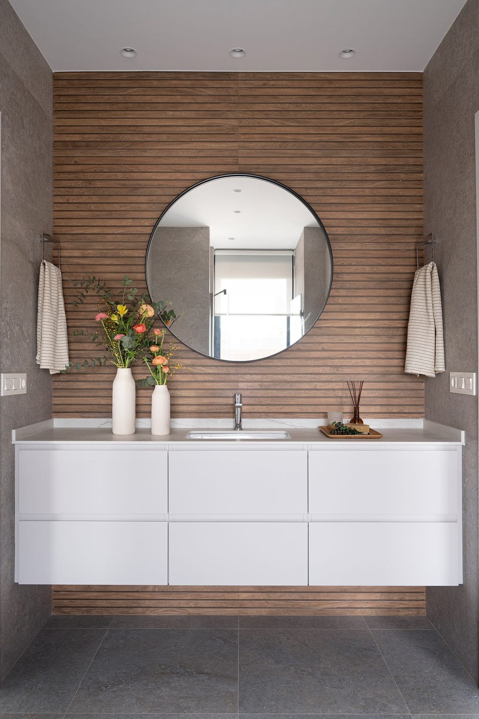 baño con mueble volado blanco y revestimiento efecto madera