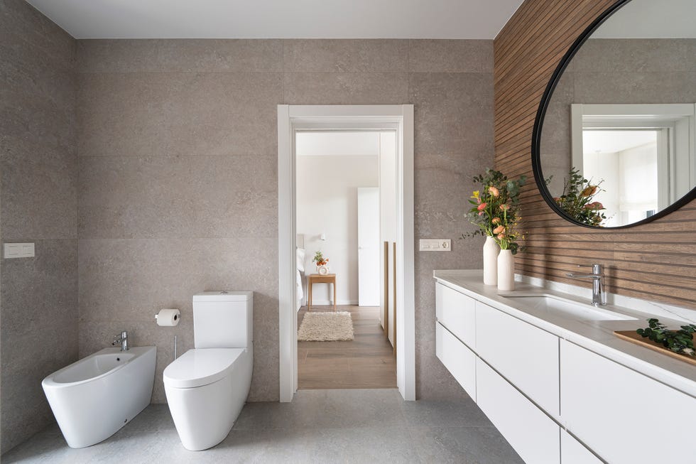 baño con mueble volado blanco y revestimiento efecto madera