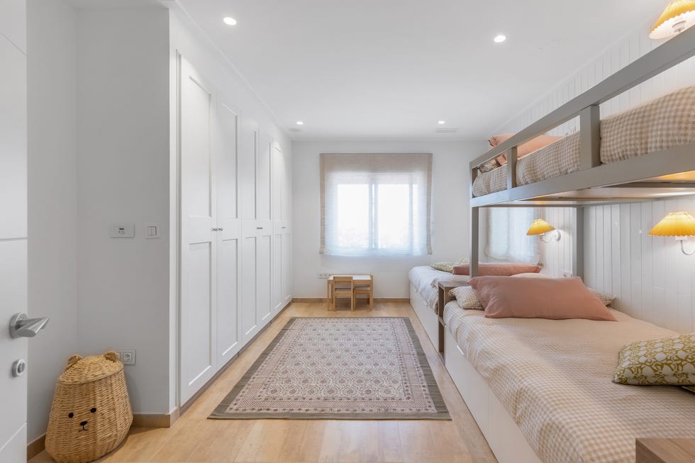 dormitorio infantil con literas y armario blanco con molduras