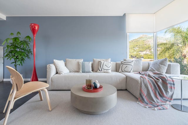salón con sofá rinconera y ventanales