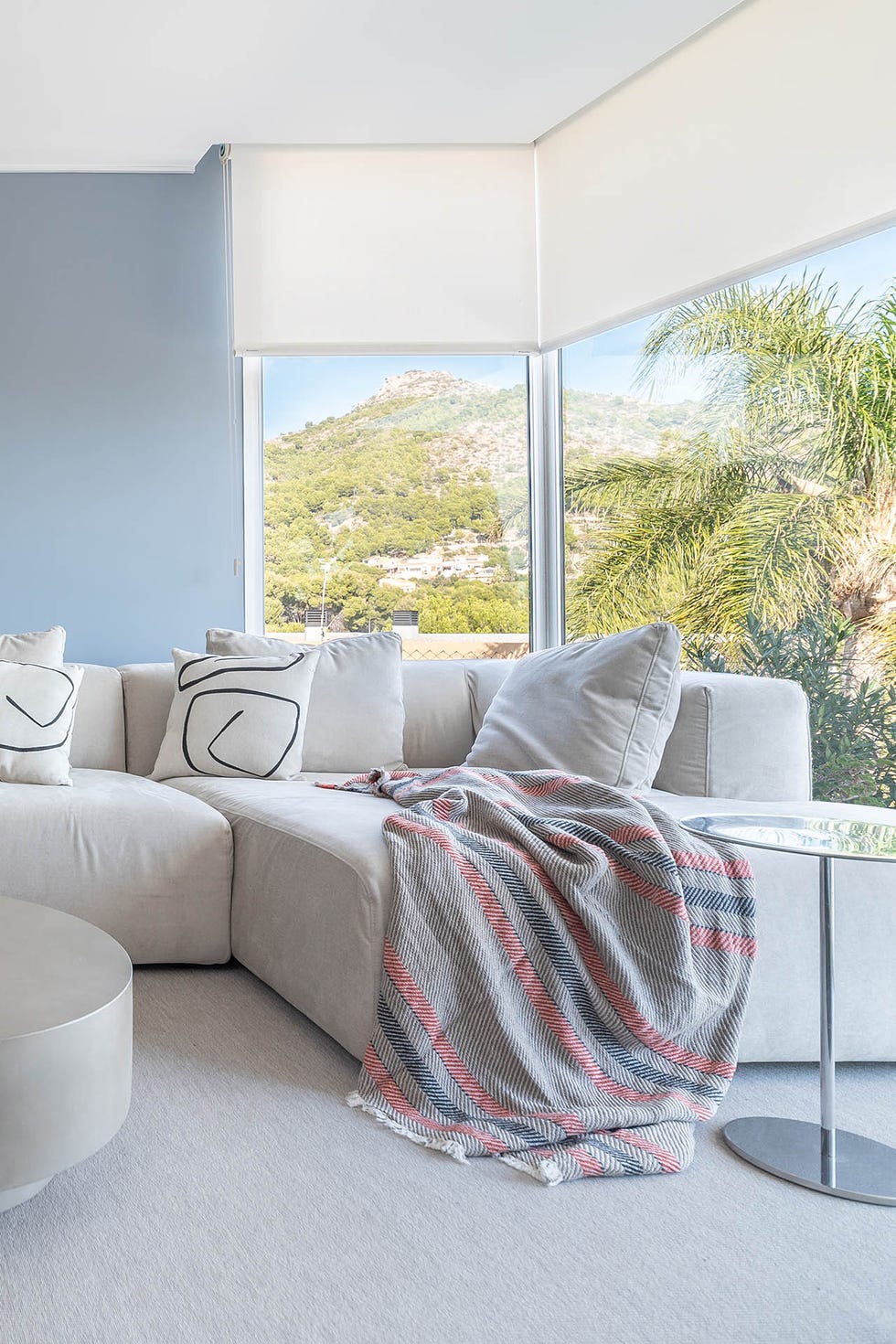 salón con sofá rinconera y ventanales