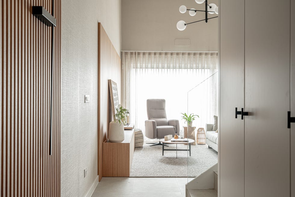 salón con butaca y muebles en tonos cálidos